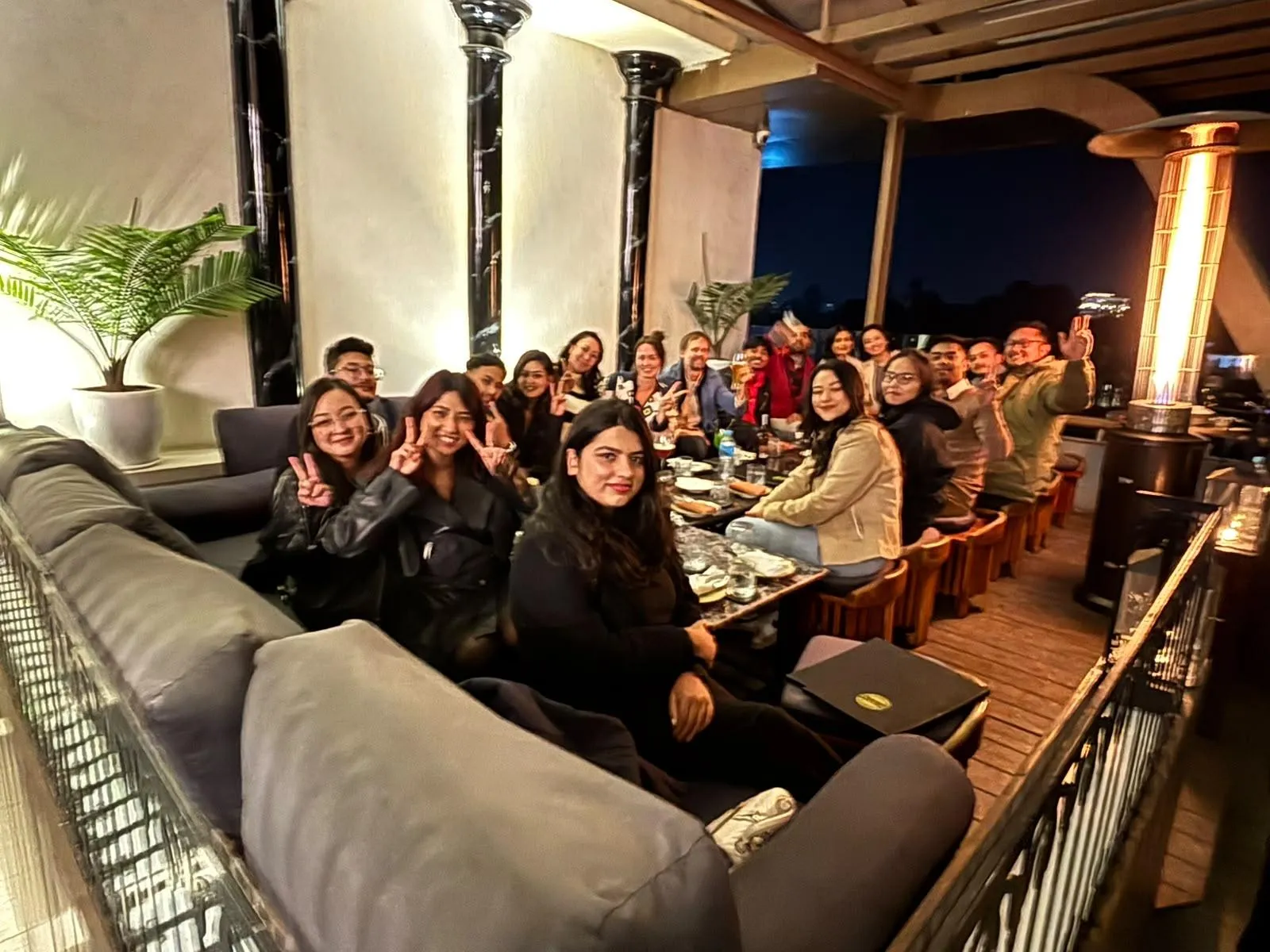 The whole team at a celebration dinner on a rooftop terrace in Kathmandu