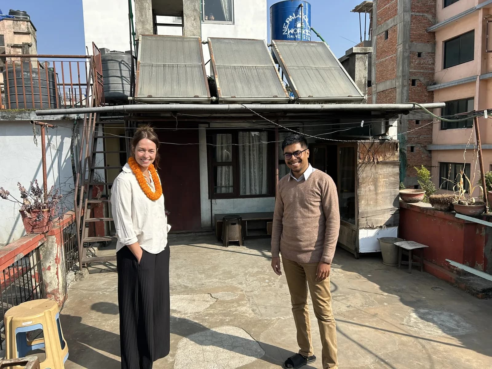A visitor from Sweden wearing a marigold garland on the office rooftop in Kathmandu