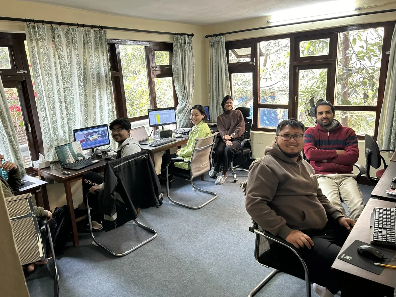 Colleagues working at desks by large windows